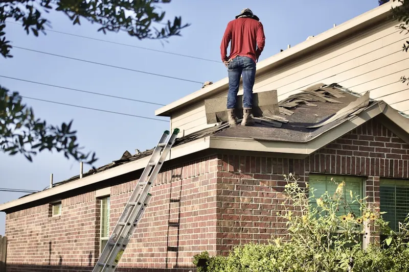 Professional roofer working on a residential roof in Kinfield Village